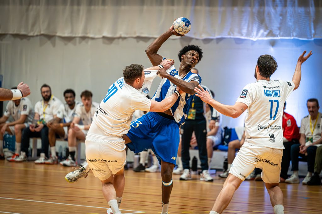 handballeur près a tirer, stoppé par les defenseurs